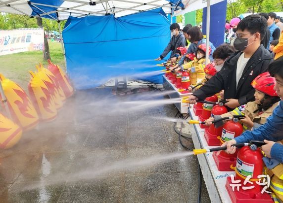 어린이들이 물 소화기를 통해 불끄기를 체험하고 있다.
