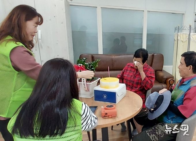 화서2동 지역사회보장협의체 위원과 동 담당자, 이웃주민이 생일을 맞으신 어르신에게 선물을 전달하며 생신을 축하하고 있다.