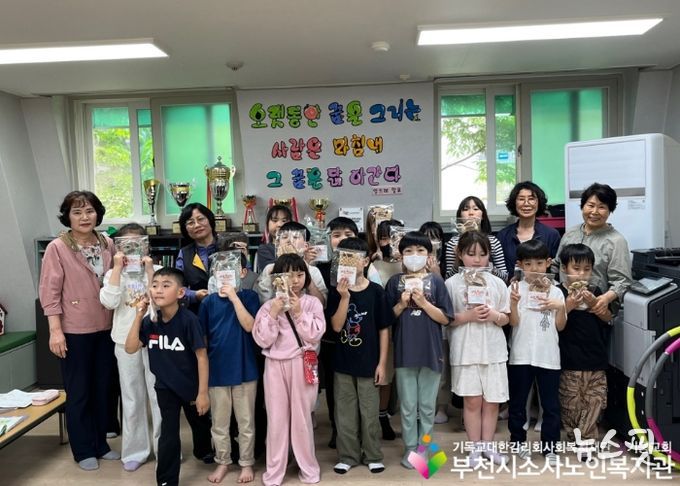 도담지역아동센터에 방문하여 아이들과 단체사진을 촬영하고 있다.