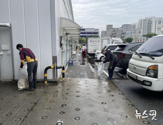 수원시농수산물도매시장에서 공직자, 상인들이 함께 대청소를 하고 있다.