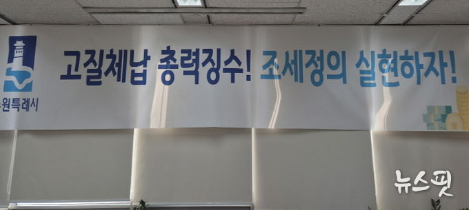 ‘고질체납 총력 징수! 조세정의 실현하자!’ 수원시 징수과 사무실에 걸려 있는 현수막.