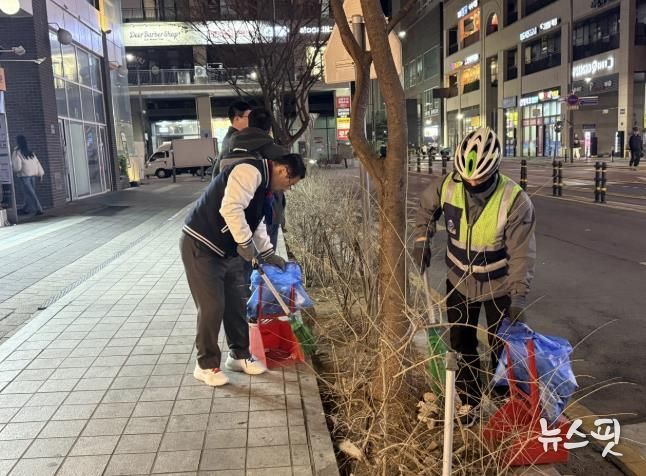 이현재 하남시장이 지난 21일 저녁 미사문화거리에서 시 소속 환경공무관들과 함께 빗자루를 들고 야간 청소 정화 활동을 펼치고 있다.