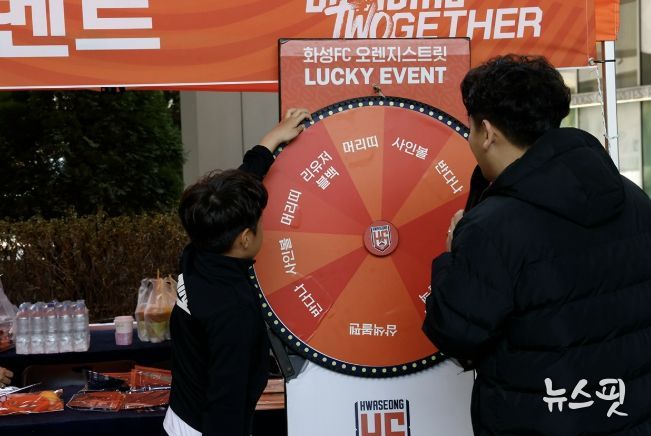 화성시민이 화성FC 게릴라 팝업 부스에서 경품 룰렛 이벤트에 참여하고 있다